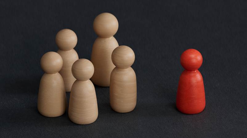 Toy block people moving away from differently colored block person - Racial Discrimination